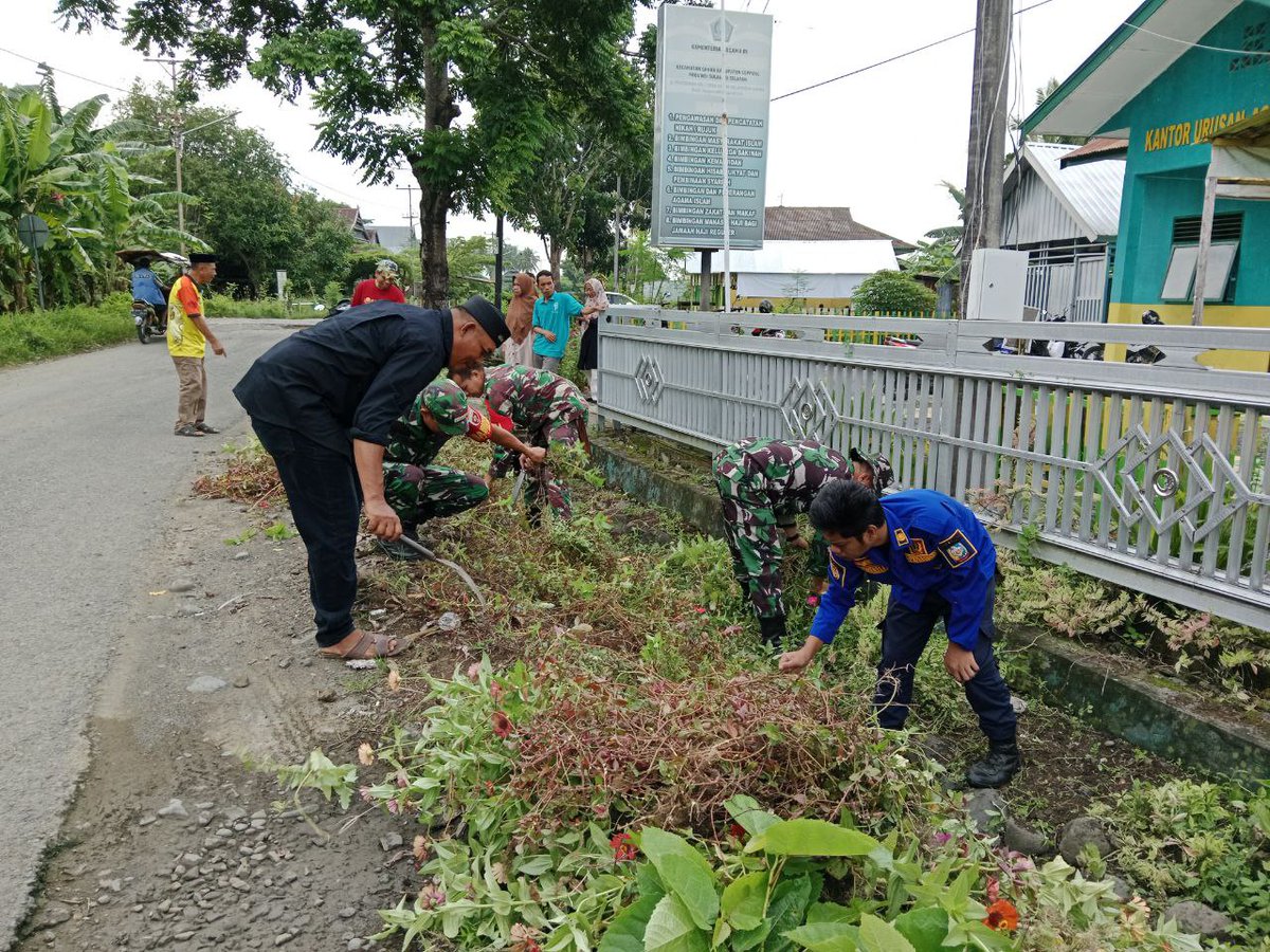 Peduli Lingkungan, Anggota Posramil Ganra Bantu Bersihkan Lingkungan Kantor KUA Kecamatan Ganra