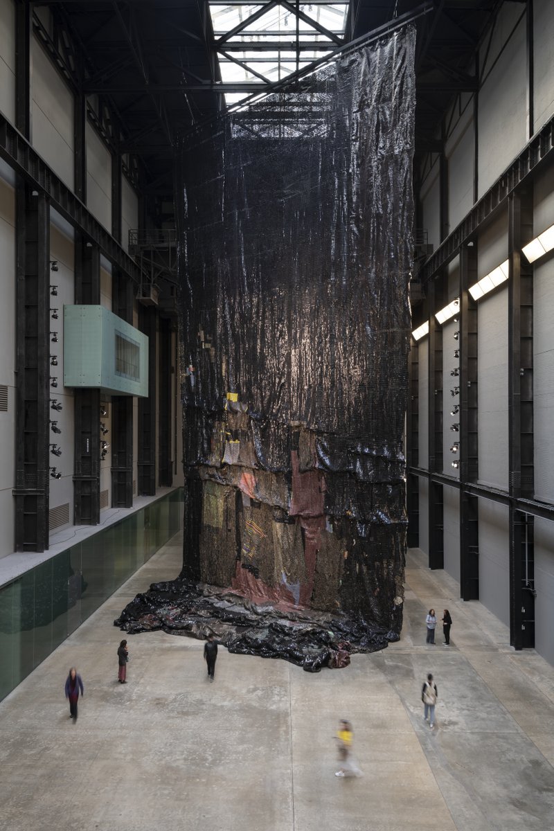 Tate's tweet photo. El Anatsui's #BehindTheRedMoon, made from bottle tops, explores colonial trade legacies. ⛵
A symbolic landscape from afar, up close, the bottle tops' logos reveal their past as commodities. Experience it for yourself at our next #TateLates on 28 March: https://t.co/l4aocTbUCZ https://t.co/lPeCNd5NPe