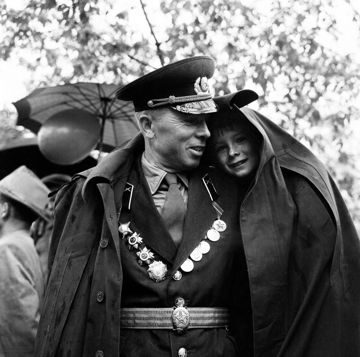 A soldier shelters his son from the rain during May Day celebrations in Tbilisi, 1960 (photo by Bela Zola)