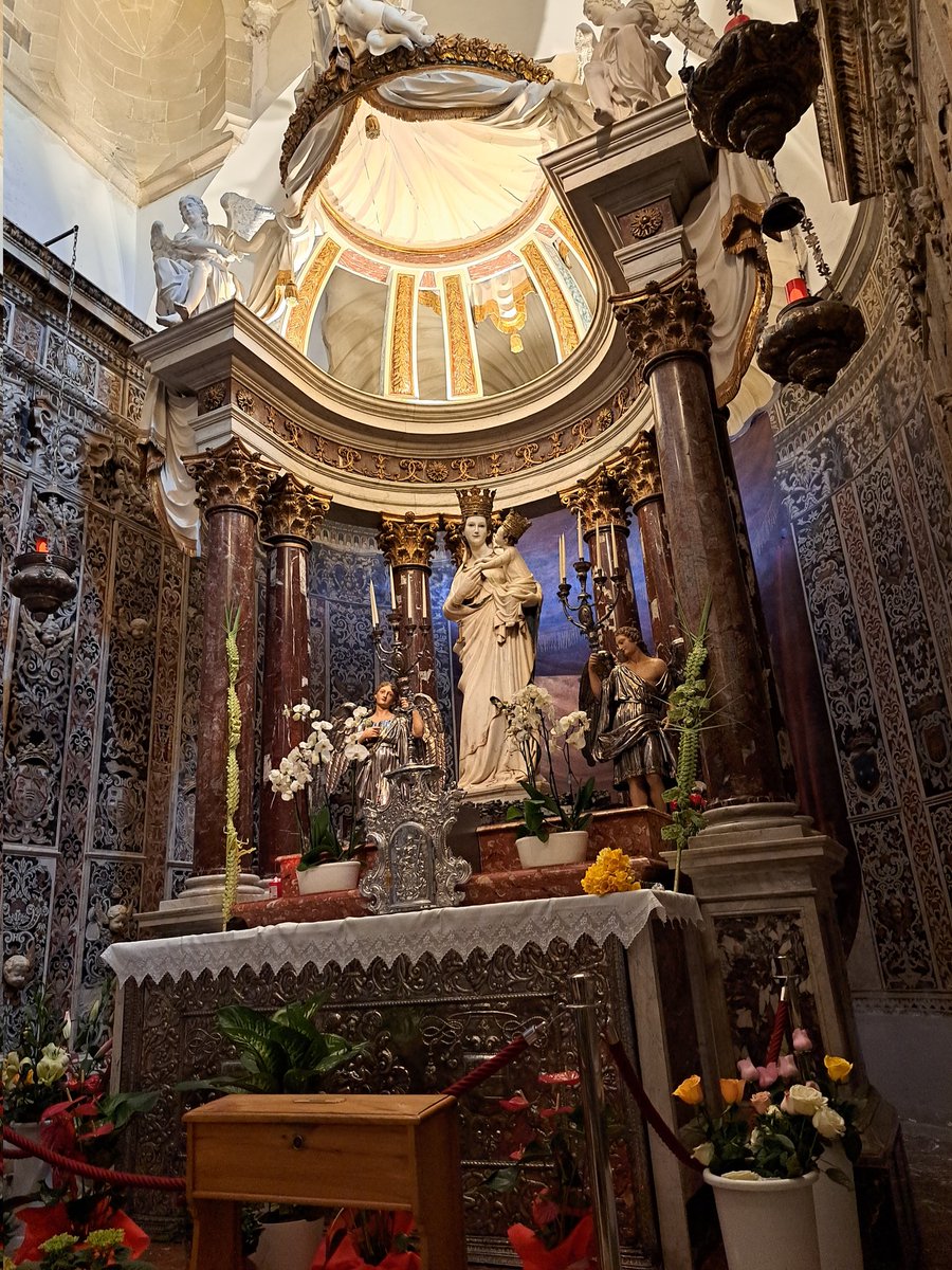 Peut-être commandée v. 1345 à Nino Pisano par un notable pisan possessionné en Sicile, la Madone de Trapani attire les regards autant que les prières de toute la Sicile et au-delà. Elle est aujourd'hui enchâssée dans l'arc sculpté par les Gagini et dans sa chapelle du XVIIe s.