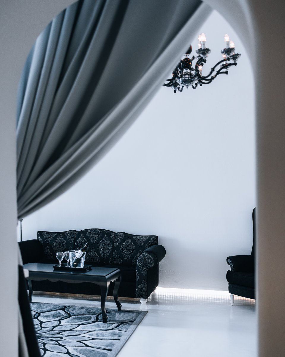 The striking contrast of the black couch against the crisp white walls sets the stage for moments of pure luxury and comfort.  ✨ 

Book directly with us at …sionvillasantorini.reserve-online.net

 #operasantorini #OperaMansion #mansion #amazingview 
#interiordesign  #Fira #Santorini #Greece