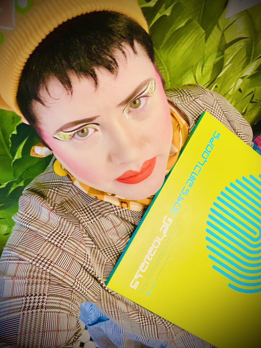 Absolutely iconic. Record: Stereolab, 'Dots and Loops.' Song: 'Miss Modular.' Face: Trixie Cosmetics: 'Girl Talk.' Hotline: 'Black and White Gel Liner.' NYX: 'On the Dot' liner. Lips: Trixie Cosmetics: 'Flamin' Hot.'