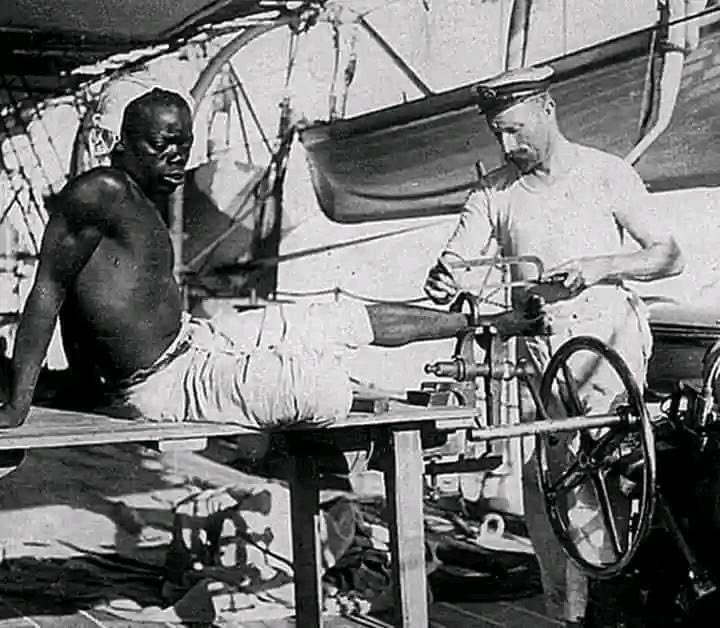 A British blacksmith removes iron from a slave, 1907, off the coast of Mozambique. So sad but his children will live to tell his story.