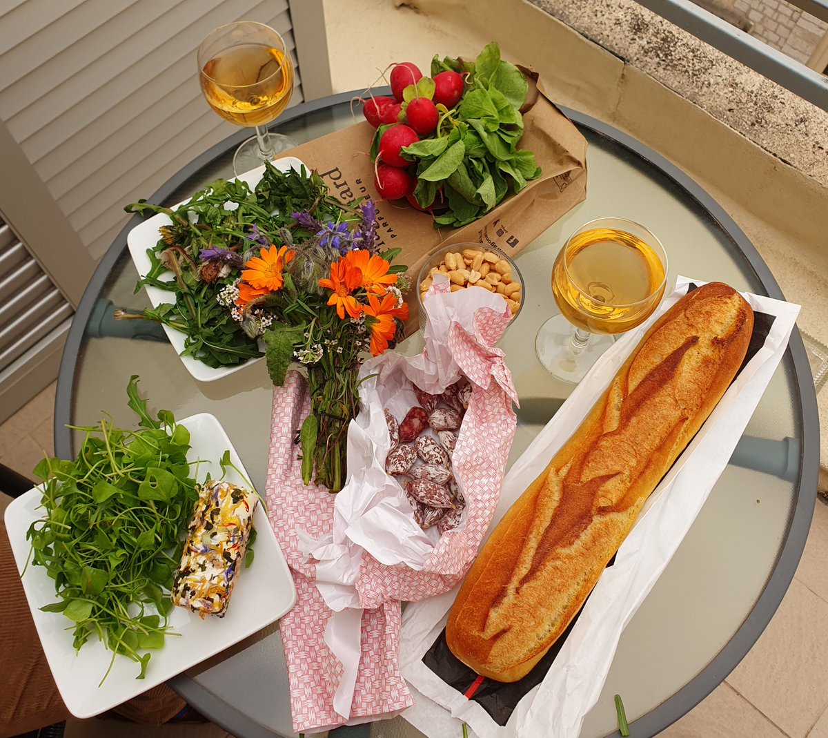 Our unintentionally floriferous lunch: dandelion leaves, pea shoots, goats cheese covered in petals and a bunch of edible flowers (with bead and saucisson on the side snd a glass of rosé)