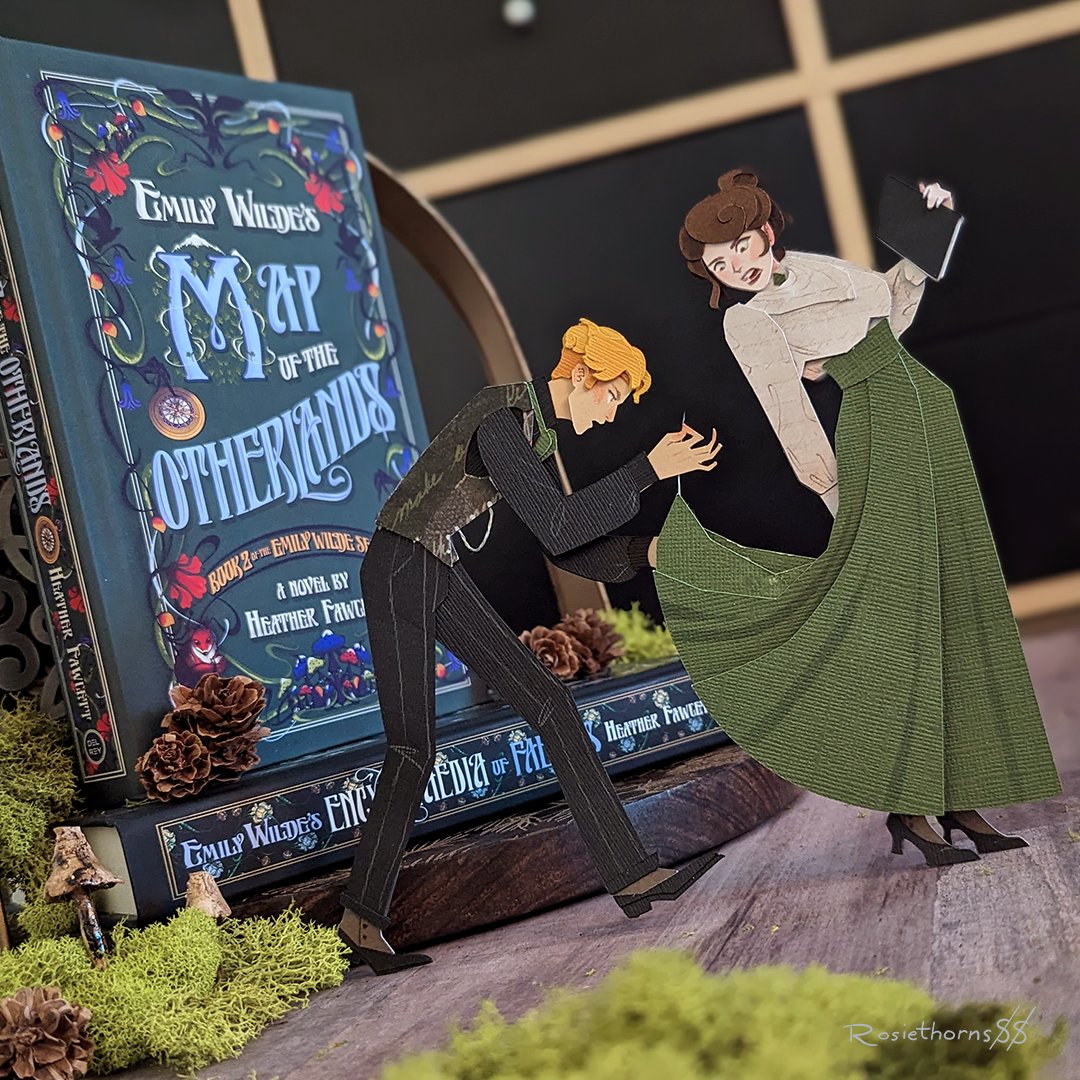 New papercraft standee, featuring Wendell and Emily from the Emily Wilde series by Heather Fawcett! I thought Wendell's obsession with mending clothes was completely hilarious and had to capture it here. 😂