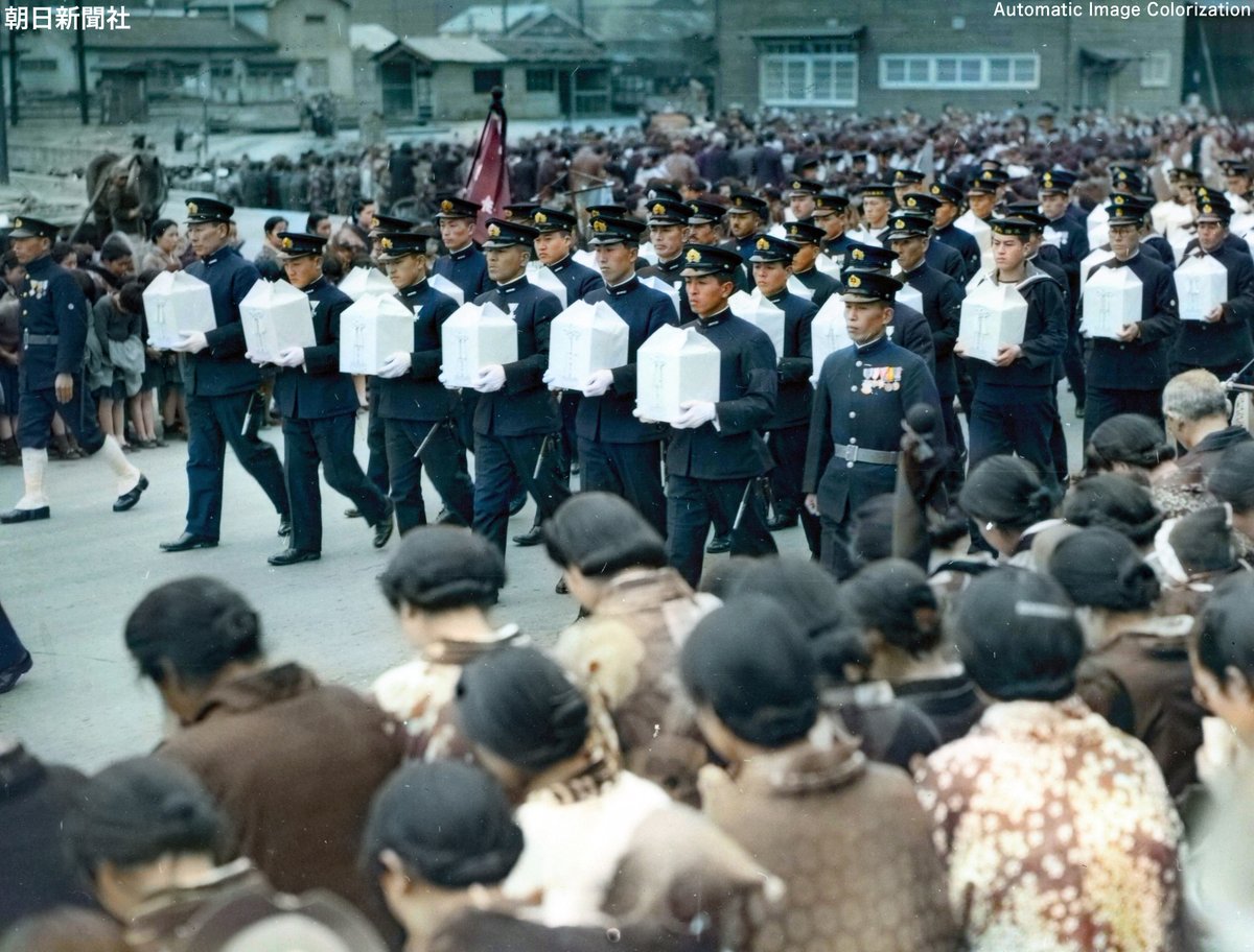 81年前の今日。1943年3月31日，呉駅前通りにて，遺骨を抱いて行進する軍人たち。特殊潜航艇の作戦で戦死した大尉らの合同葬。ニューラルネットワークによる自動色付け＋手動補正。（写真：朝日新聞社）