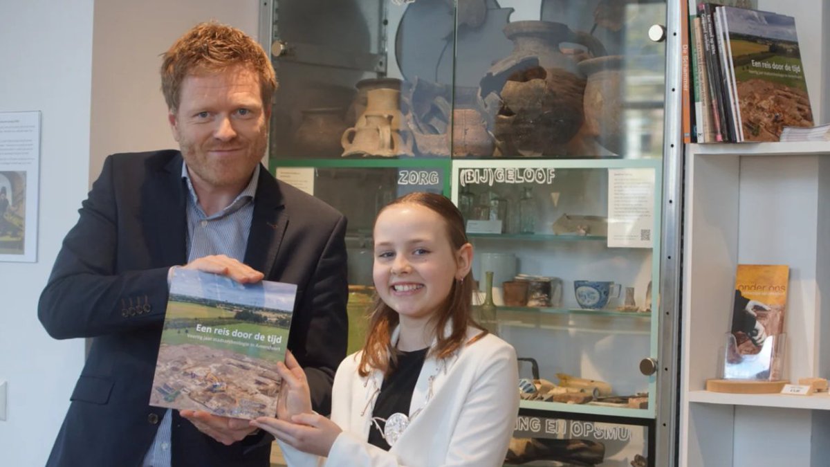 Feestelijk jubileumjaar voor het Centrum voor Archeologie Amersfoort, dat 40 jaar geleden de eerste stadsarcheoloog verwelkomde! Kinderburgemeester Lynn Verhoeven ontvangt 'Een reis door de tijd' van wethouder Rutger Dijksterhuis om het jaar te starten. rb.gy/qt46f0