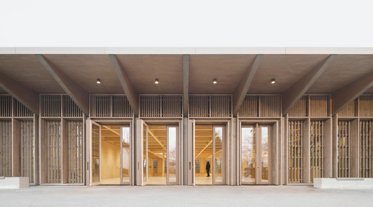 arquitect_viva's tweet photo. Pabellón polivalente Markelfingen. Alemania
Steimle Architekten
https://t.co/eToYaAJouJ
Situada en la orilla norte del lago Constanza, la matérica construcción es el centro de la vida comunitaria de la localidad alemana. La fachada con listones de madera, dispuestos verticalmente, confiere al edificio un aspecto homogéneo en sus cuatro frentes, acentuado por una cubierta, también de madera, con un amplio voladizo que se extiende en todas las direcciones.