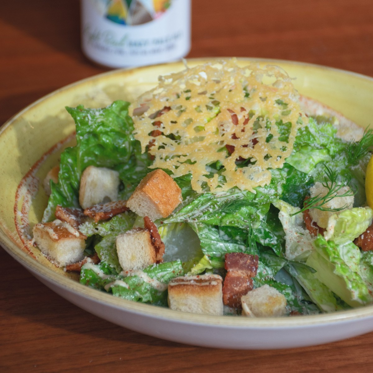 Introducing: Chef Mat's Caesar Salad! Crisp, crunchy, and oh-so-satisfying, it's the perfect pick-me-up for any day of the week. Romaine lettuce, house dressing, croutons, bacon lardons, fresh dill, crispy gouda