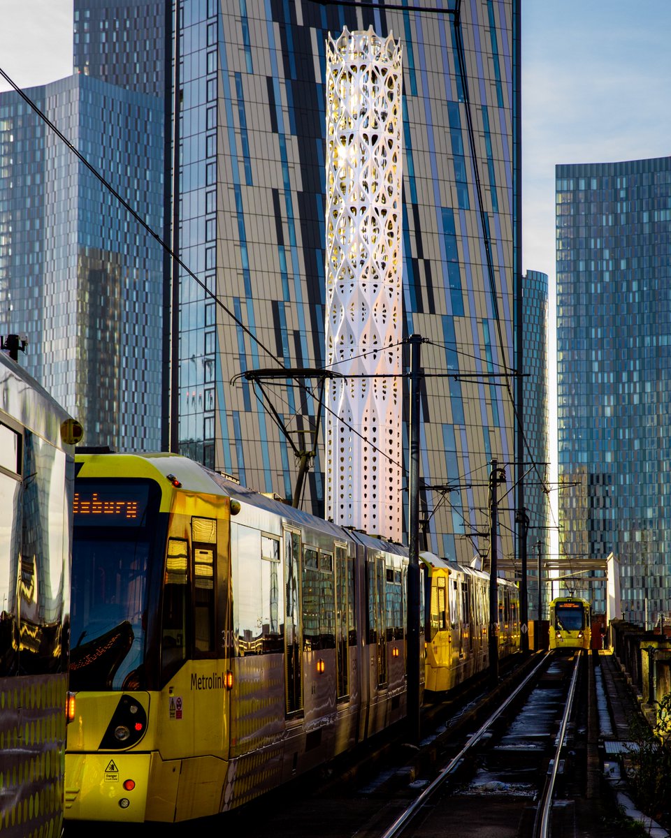 Trams passing Tonkin Liu's award-winning Tower of Light which captures the energy of the sun and the power of the wind to provide low-carbon energy to the Civic Quarter Heat Network.