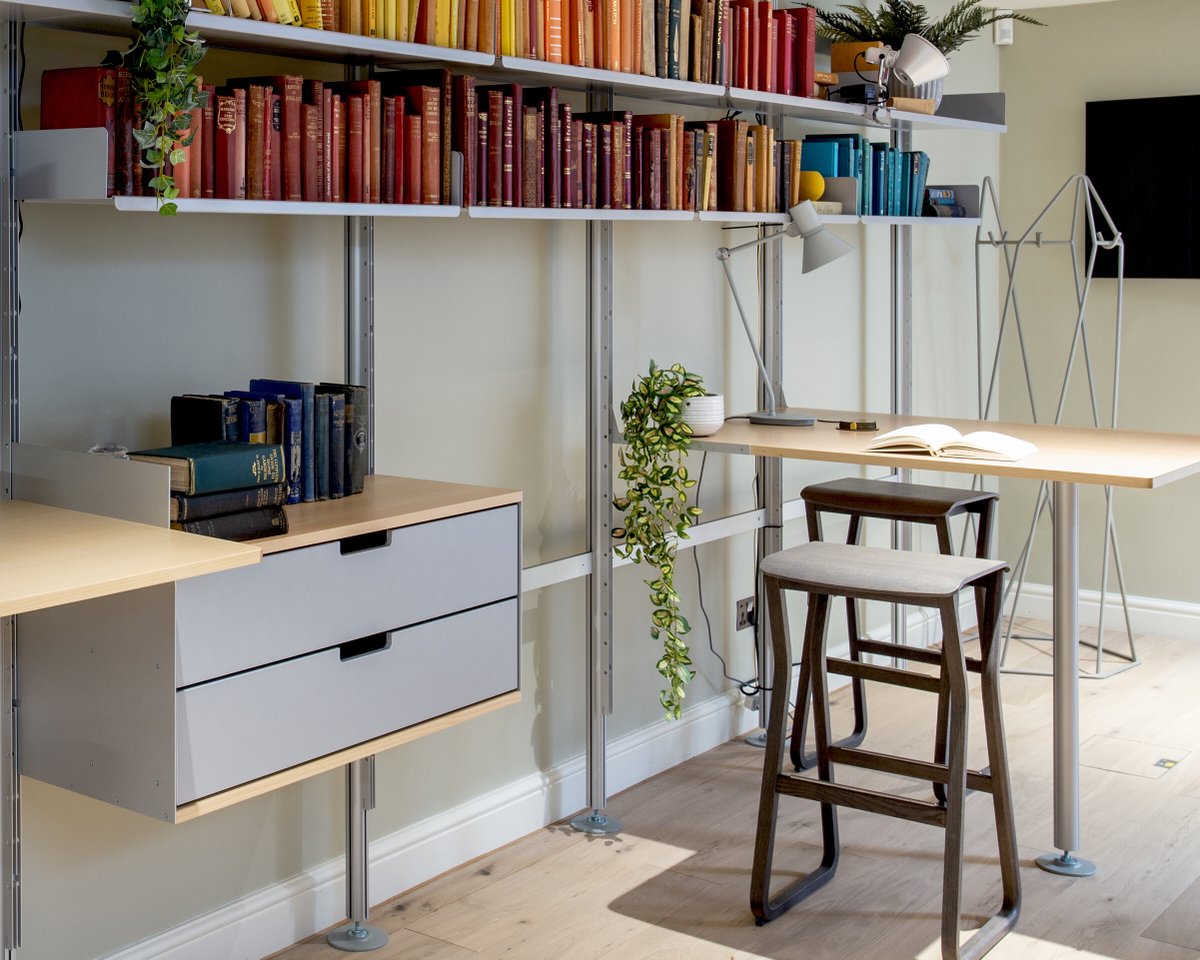 Bath rooms Silver & beech semi-wall-mounted 606 shelving systems with cabinets and integrated desk-tables at House of St John’s, a work/office/events space and social-enterprise supporting disadvantaged children in Bath, UK. Plan your own office system: vitsoe.com/606