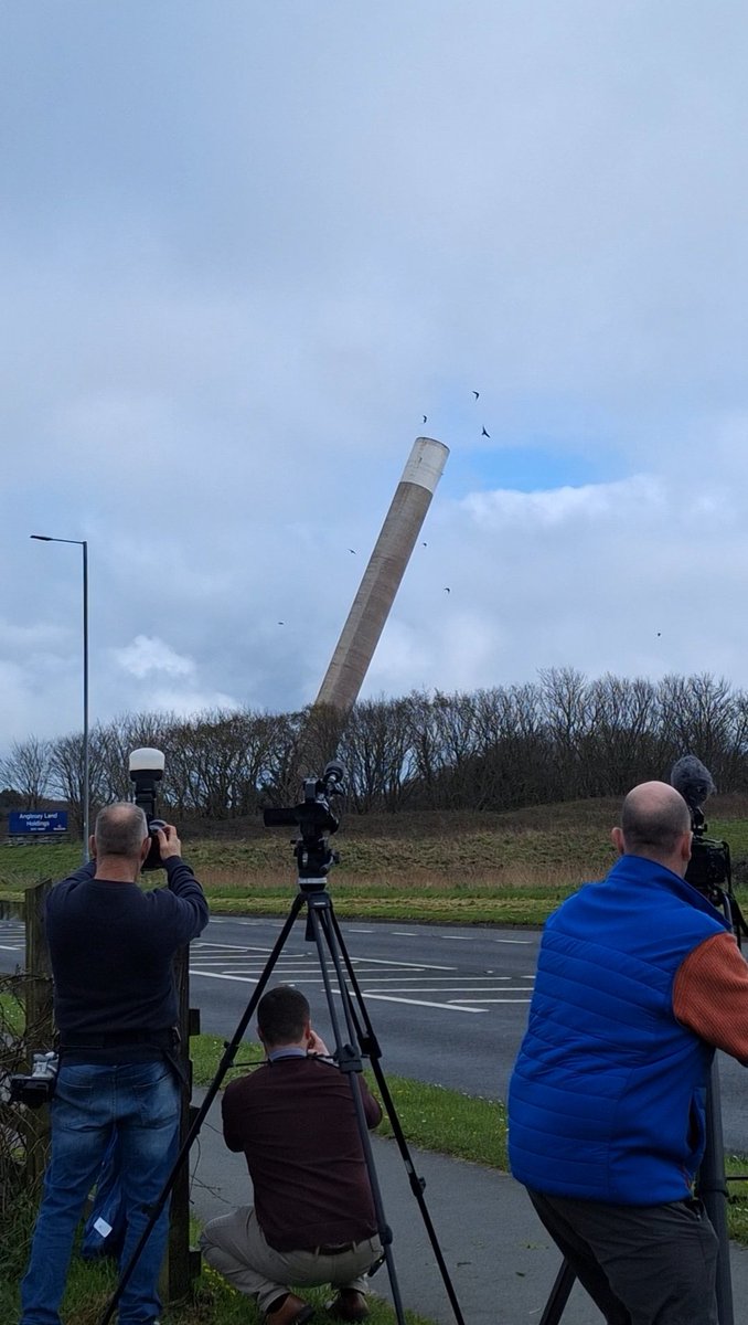 There she goes.... Anglesey Aluminium chimney falls to the ground after the button is pressed by competition winner Geraint Williams, in the prize draw, proceeds of which are being donated to our station! What an experience for him and wife Lyn 😲💥