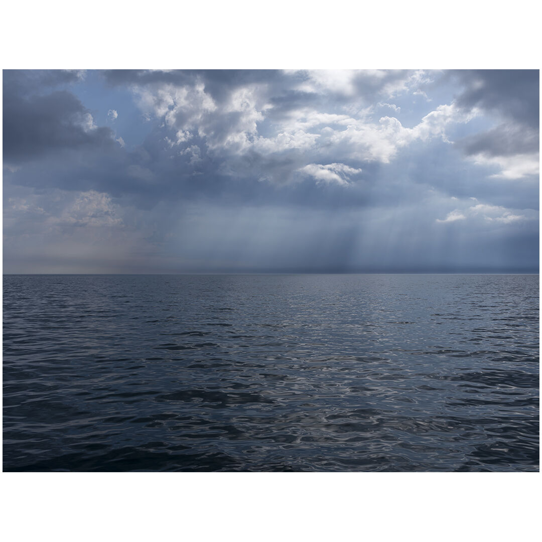 A morning on the lake where the sunlight splits clouds apart, dramatically slashing and illuminating the sky while water and light interact to create a dappled surface on Lake Michigan.