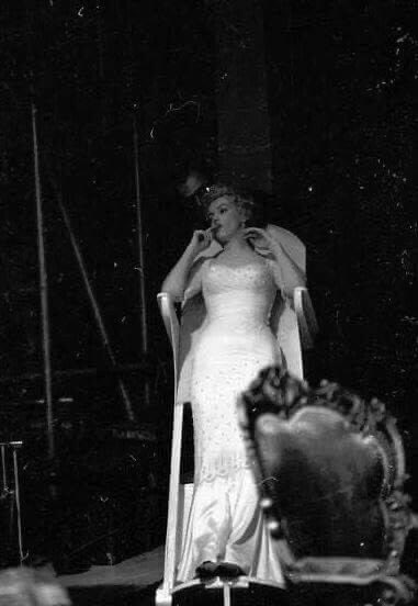 Resting between takes on a costume department board The Prince and the Showgirl, 1956. Her husband, the playwright, Arthur Miller giving reassurance in the background. Miller is much maligned however; his devotion to her wellbeing and career placed him in a ‘no win’ situation