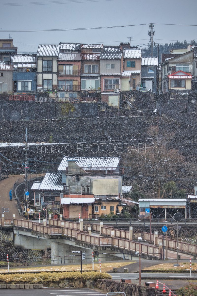 屋根が白くなった家々が並ぶ西町の石垣。 今日の富山は平野部でも雪が降り、真冬のような寒い一日となりました。 写真は今日、富山市八尾町で撮影。