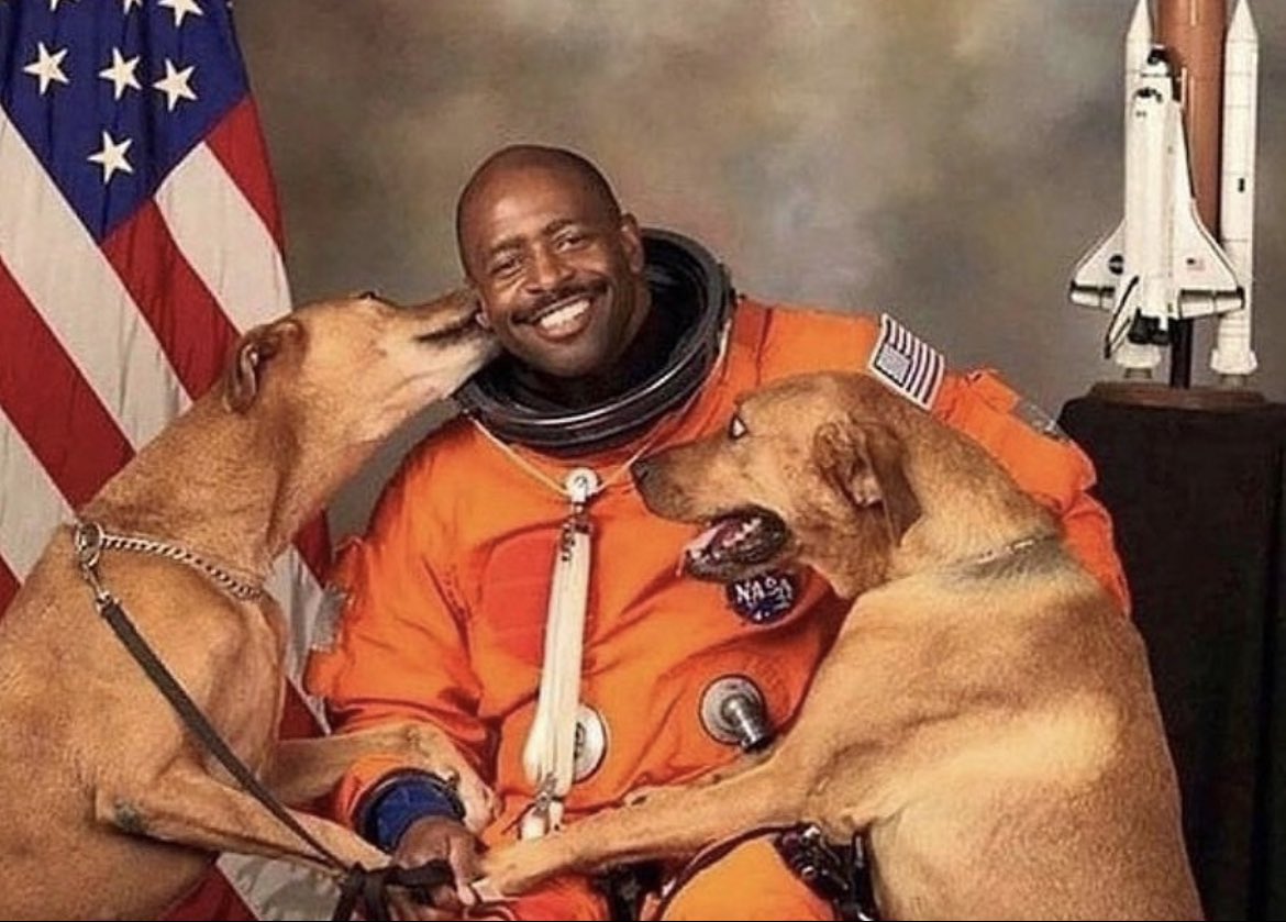 For his official NASA portrait in 2008, astronaut Leland Melvin decided to include his rescue dogs, Jake and Scout, even though dogs weren't usually allowed at the photo shoot. 

He sneaked them onto the base and into the photo lab using his van. To keep the dogs quiet during his