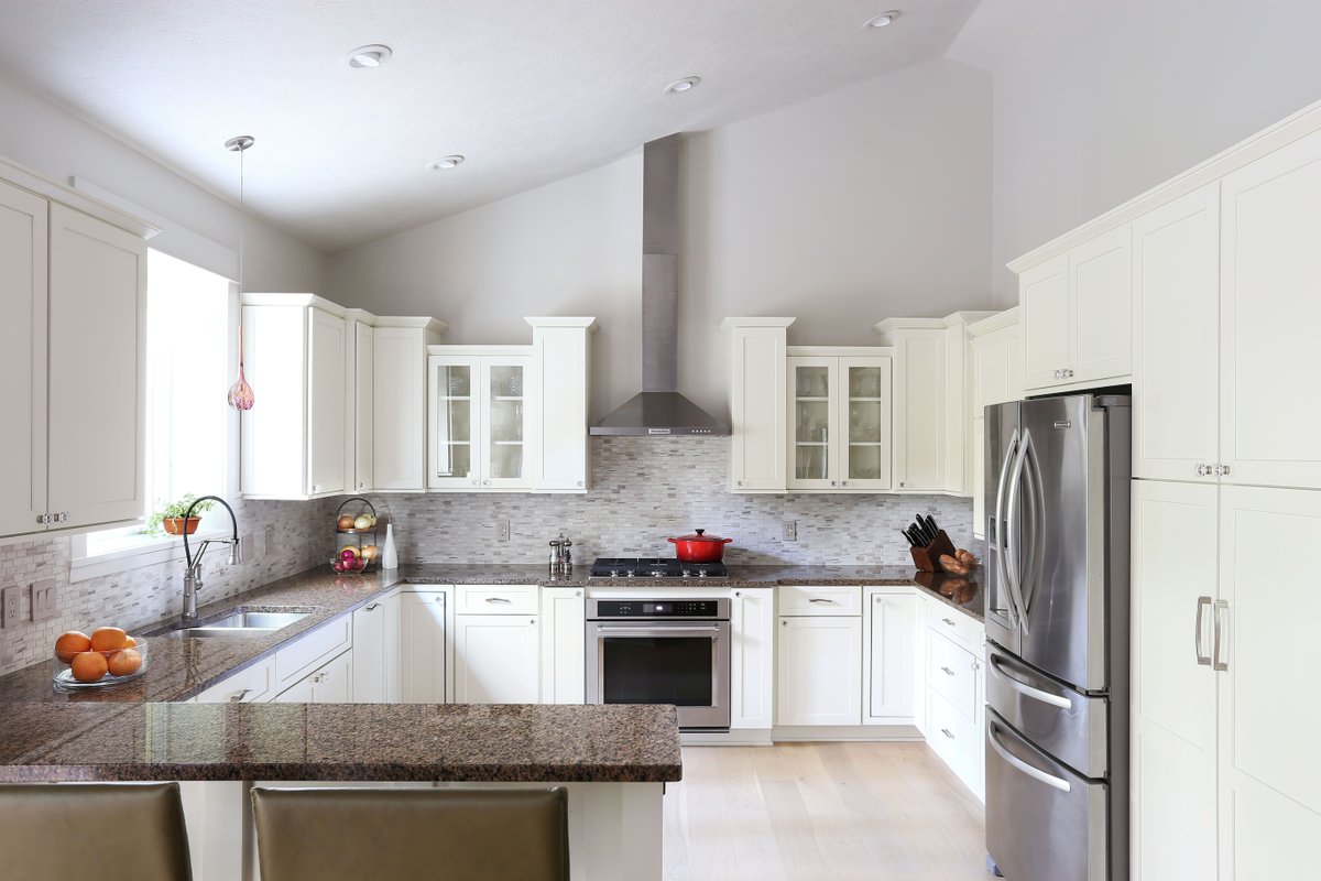 This kitchen refresh includes newly painted cabinets with custom doors, a new backsplash, white oak floors, and updated fixtures, hardware and lighting. Simplifying the design breathes new life into this space. #AndyYatesDesign #InteriorDesign #KitchenDesign #ExceptionalDesign