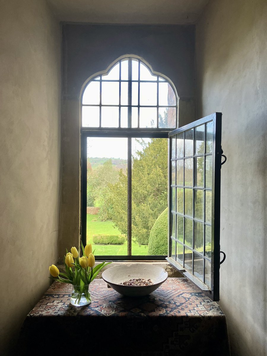 It’s Friday and the windows are open on a warm spring day and the air is richly seasoned with wood smoke and newly-turned earth from the rose bed beneath.