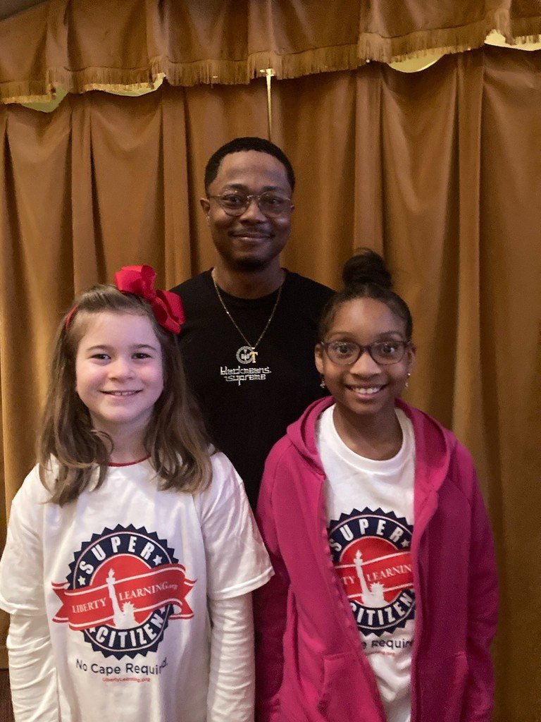 Friday Spotlight! Carsen Gilmore and Rayna McCallum read a tribute to Mr. Lamar and presented him with a torch pin in honor of him being named Forest Avenue's Helping Hand Hero for 2024.