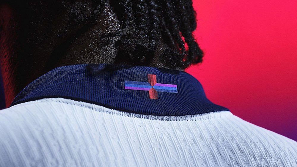 MRickman88's tweet photo. Anyone up in arms and protesting about a simple little different coloured cross on the neckline of the new England Shirt needs to give their head a wobble. If that’s your biggest concern in life then you’re living in dream land. https://t.co/HJwZP1dwfi