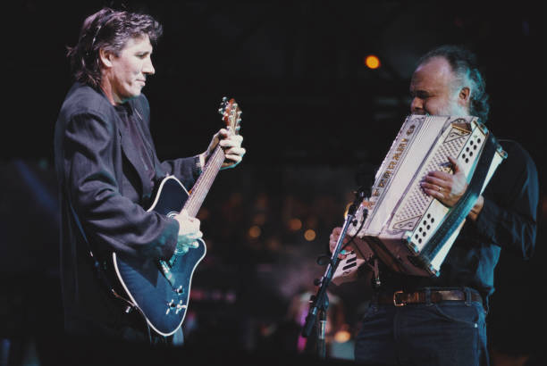 Roger Waters performs live on stage with Garth Hudson during a concert version of 'The Wall,' Berlin, Germany, July 21, 1990. The concert commemorated the fall of the Berlin Wall and was released as the live album 'The Wall – Live in Berlin.' Photo: Michael Putland