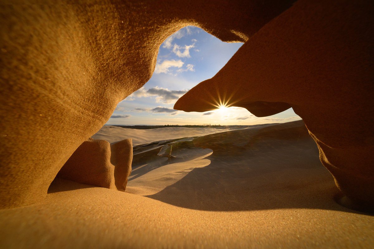 A small sandstone arch formation set aglow by the morning sun.  Silver Lake Sand Dunes - Mears, Michigan.  
#puremichigan