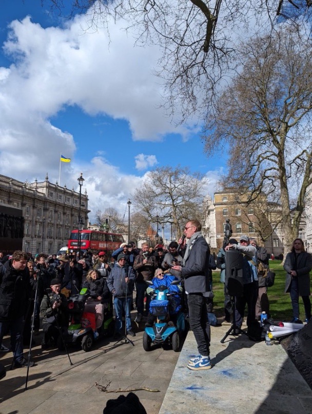 Laurence Fox is talking to people at the Cenotaph about the evils of Nike. While wearing Nike trainers.