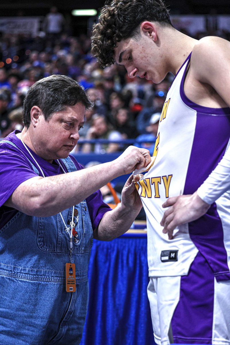 TenthRegion's tweet photo. The unsung hero of the Sweet 16 is Lyon County’s trainer, who cleaned blood off several players’ jerseys in the fourth quarter.  She is sporting her jean bib overalls embroidered with Mickey Mouse playing basketball. https://t.co/XJJqY081tu
