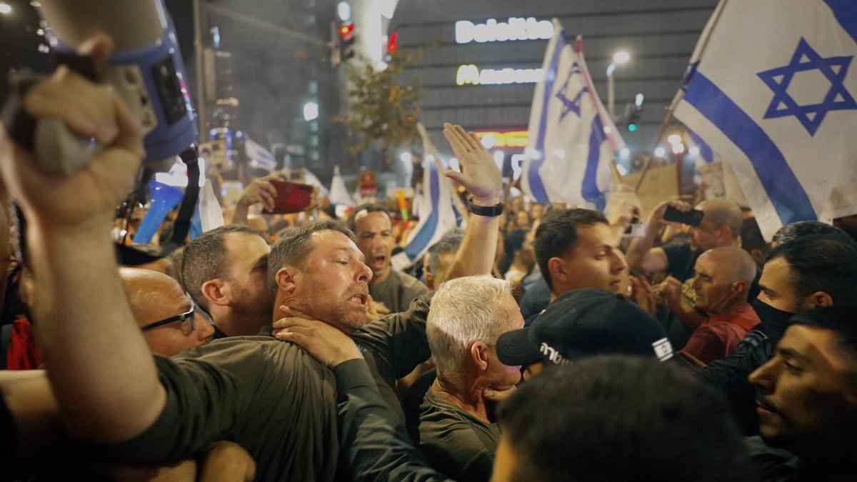 בתמונה איל נוה מייסד אחים לנשק, נחנק על ידי שוטר צעיר ואלים שלא מבין את תפקידו. אנחנו מוכנים לשלם מחירים לטובת עתיד המדינה האהובה שלנו. לספוג קללות, איומים, השמצות מצד ממשלת ישראל מכונת הרעל ושופרותיה. לשלם בזמן יקר עם משפחותינו, לתרום כספים למאבק, להתנדב בכל דרך אפשרית לבנייה…