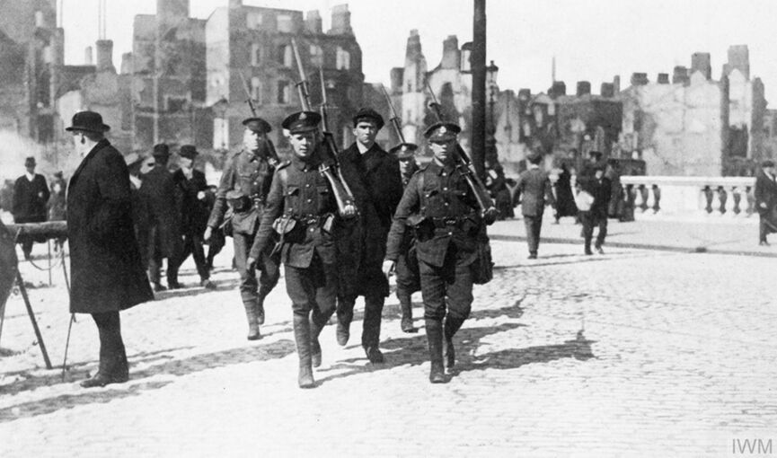 On 24 April, 1916, Irish republicans seized notable buildings in Dublin and proclaimed an Irish Republic in what became known as the Easter Rising. Here an arrested Irish republican is marched across a bridge by British troops in the aftermath of the fighting. © IWM HU 55529