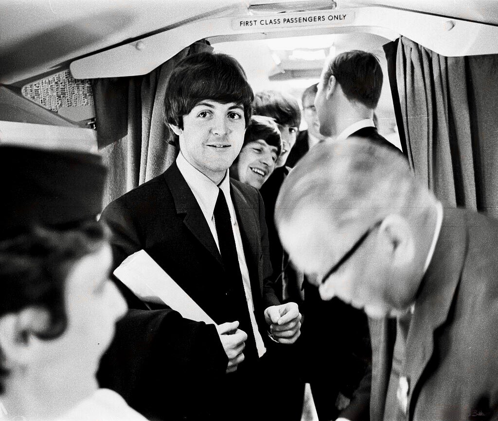 Paul McCartney on a SAS Caravelle flight to Stockholm, Sweden 28th July 1964. Other giggling Beatles can be spotted behind him…