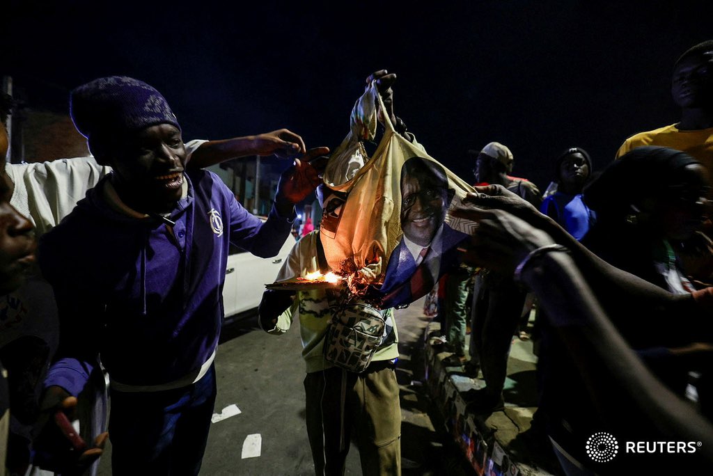 Supporters of Senegalese presidential candidate Bassirou Diomaye Faye burn a tee shirt bearing the picture of his rival Amadou Ba while celebrating early results showing that Faye is leading the initial presidential election tallies, in Dakar, Senegal, #Kebetu