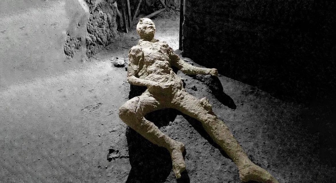 interesting_aIl's tweet photo. This photograph, released in 2017, showcases the remains of an individual who lived in Pompeii during the eruption of Vesuvius in 79 AD.  

The posture of the body led to speculations suggesting that the man had died while masturbating. 

However, according to volcanologist Dr. Petrone: “Most of the human victims found in Pompeii often show ‘strange’ position of arms and legs, due to the contraction of limbs as a consequence of the heat effect on their bodies after death occurred”.