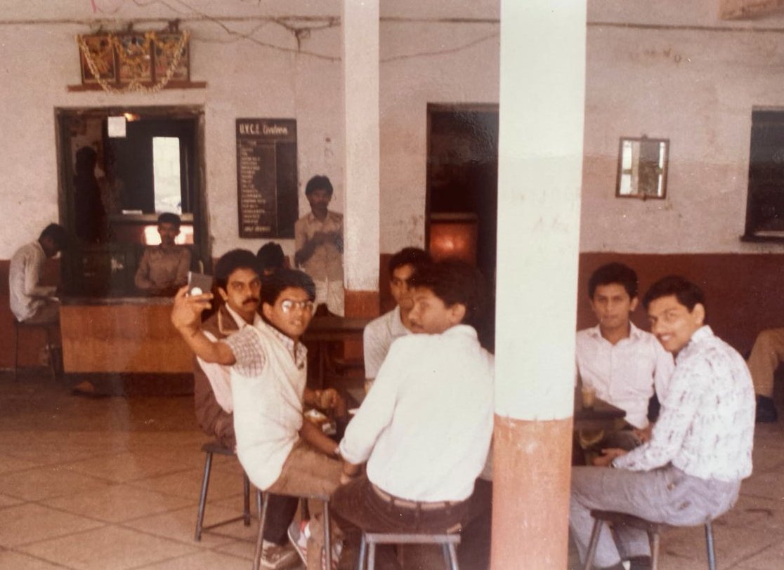 TheSwamy's tweet photo. A close friend of mine dug up this photo taken at the #UVCE college canteen - where a disproportionate part of my undergraduate time was spent. 

Anyone who looks at this photo reacts with, "You were taking a Selfie - even in 1986" 🤪

I guess it was the one lasting skill that I got out of my undergrad in Electrical Engineering - 30 years before the  emergence of #TheSelfieSwamy.

PS: From a privacy perspective, I probably should be blurring out the other faces but I'm guessing it's going to be hard for most AI to identify them anyways - but believe it or not, all of us are #STILLBESTFRIENDS😅