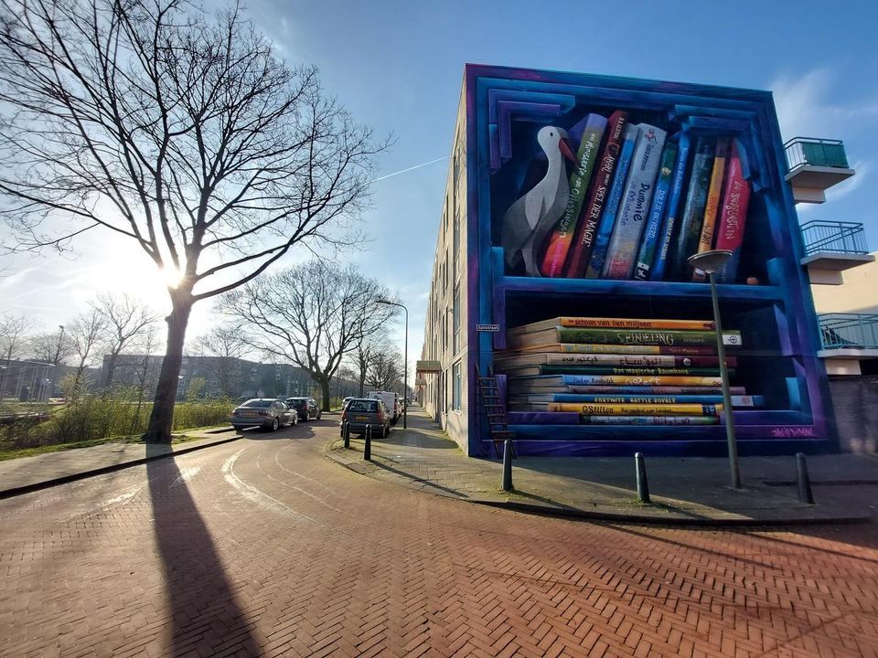 Via @GemeenteDenHaag, artist JanIsDeMan created another fab bookcase mural on Spilstraat in Molenwijk. He worked w/ neighborhood children to select their fav books for the bookshelves, including @bb_alston's 'Amari and the Great Game'/'Amari en het Spel der Magiërs'