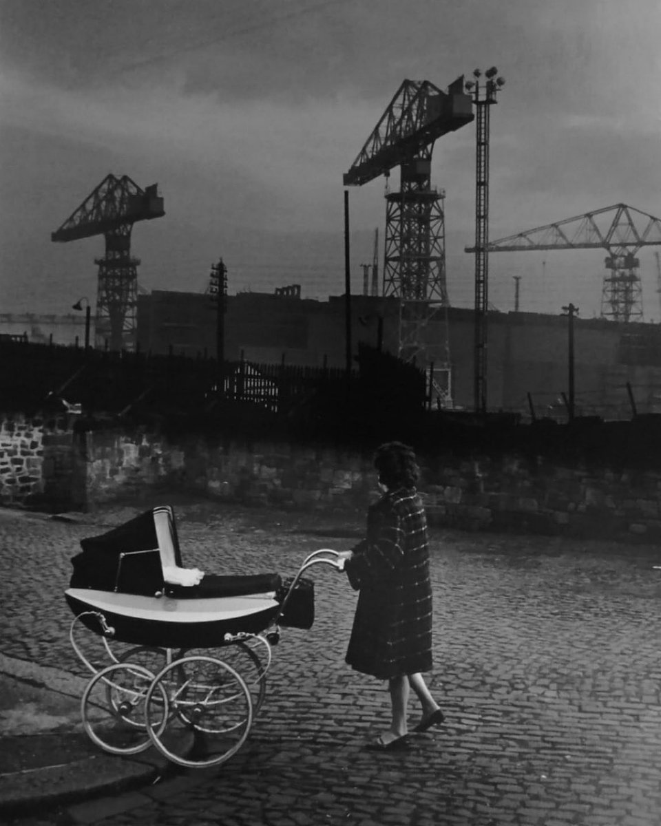 Mother with pram walking past Swan Hunters shipyard, Wallsend, England, 1962 - by Colin Jones (1936 - 2021), English