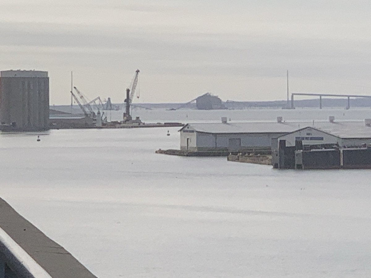 View of Baltimore's Key Bridge from my balcony. The black lump in the middle is the cargo ship that collided with it in the night, completely destroying the central span.