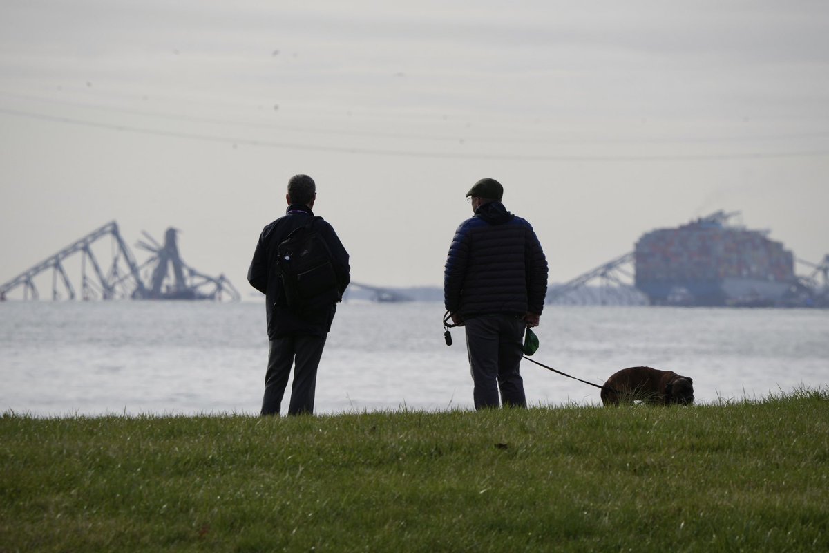 Two men at Ft. McHenry look out at where the Francis Scott Key bridge used to be … a cargo ship collided with it early Tuesday morning, collapsing the bridge into the Patapsco River. 📸 @BaltimoreBanner thebaltimorebanner.com/community/tran…