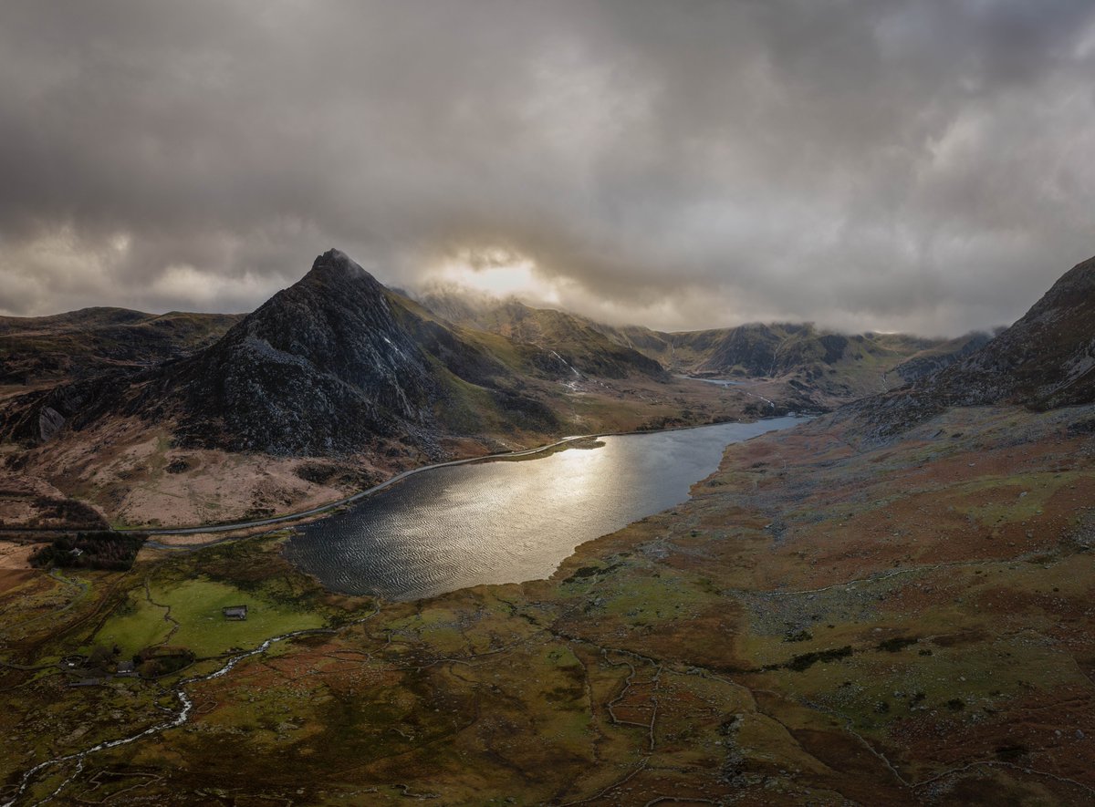 The sun pokes through a moody sky over Tryfan and Llyn Ogwen.  @DJIGlobal #Dronephotography