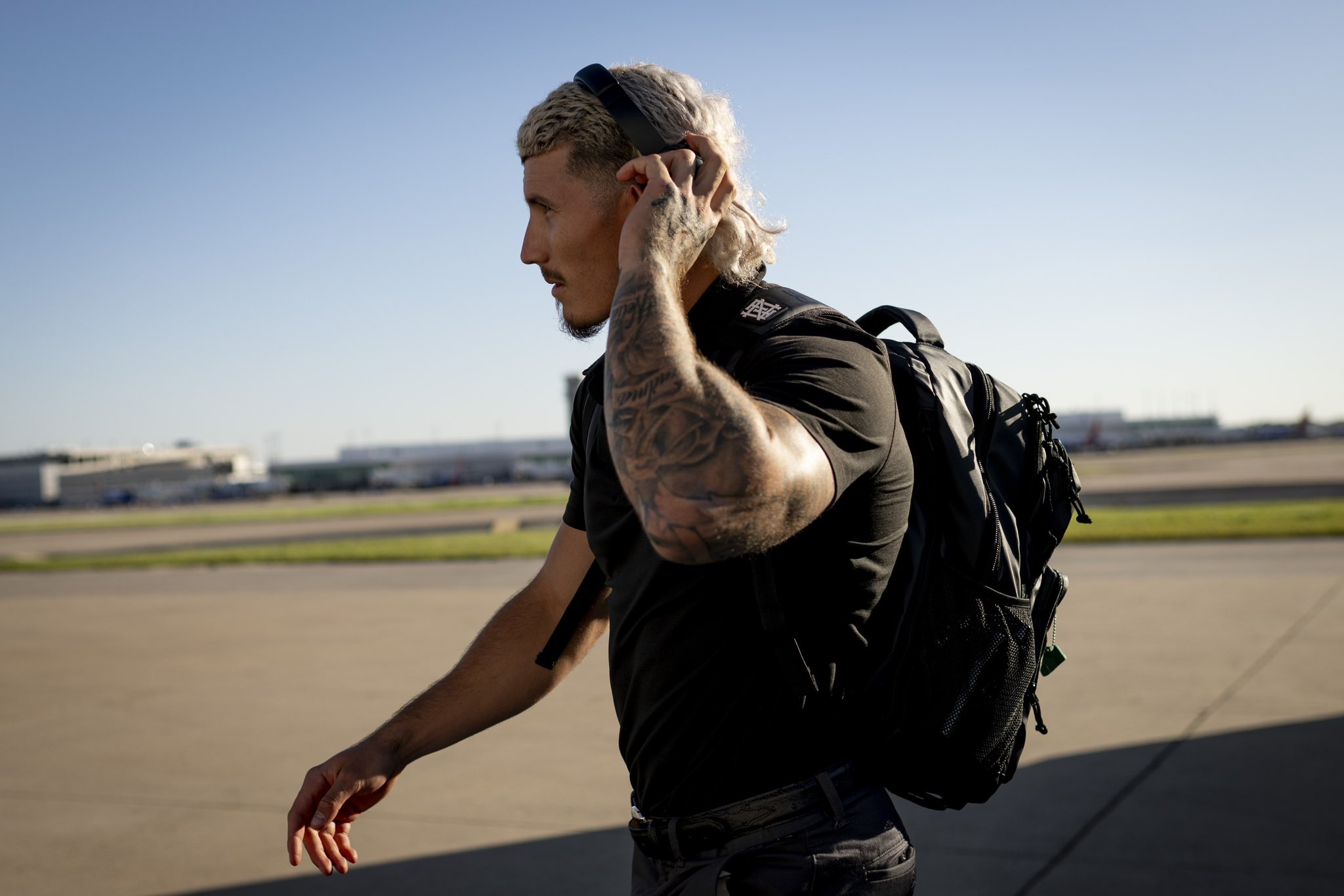 Jarren Duran takes off his headphones as he walks on the tarmac to board a flight to Seattle.