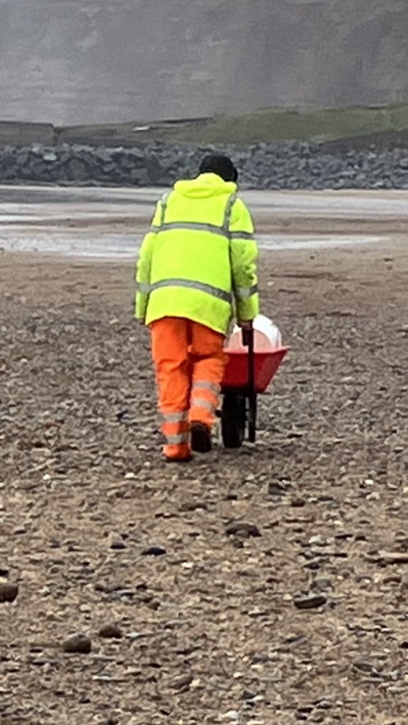 Bright and breezy day on the beach, local mussel and winkle picker with his free seafood for the day