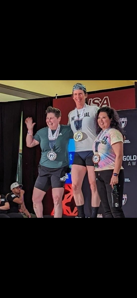 Such a sad and disgraceful photo on so many levels.  
A mediocre male crushes a women's weightlifting competition. Just goes to show the post puberty advantages and the 60%  advantage men have in strength sports over women.

Do you know what's worse?  The smiling women supporting