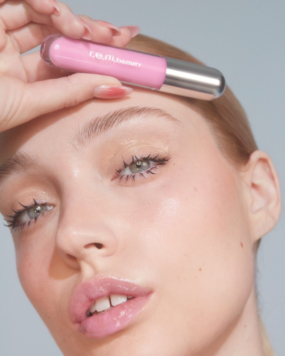 a splash of hydrating color 💧🌸 essential drip glossy balm is a nourishing lip treatment that doubles as a high-shine tinted gloss, available on rembeauty.com on 4.2 featured here in shade “skinny dripped”