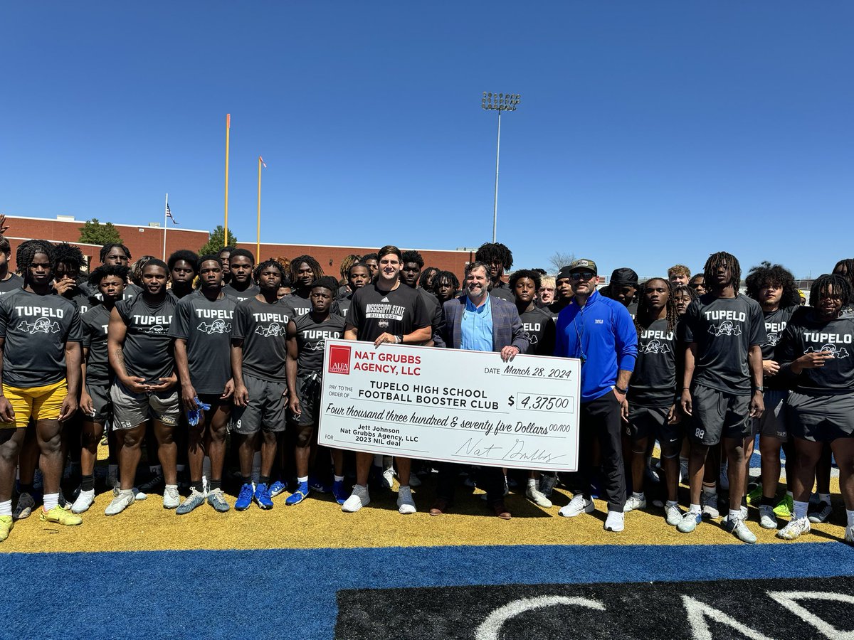 Tupelo and Mississippi State alum Jett Johnson presents Tupelo football with a $4,375 check as a part of an NIL campaign with the Nat Grubbs Agency. The agency donated a certain amount of money for every big play the linebacker made in his final season in Starkville.