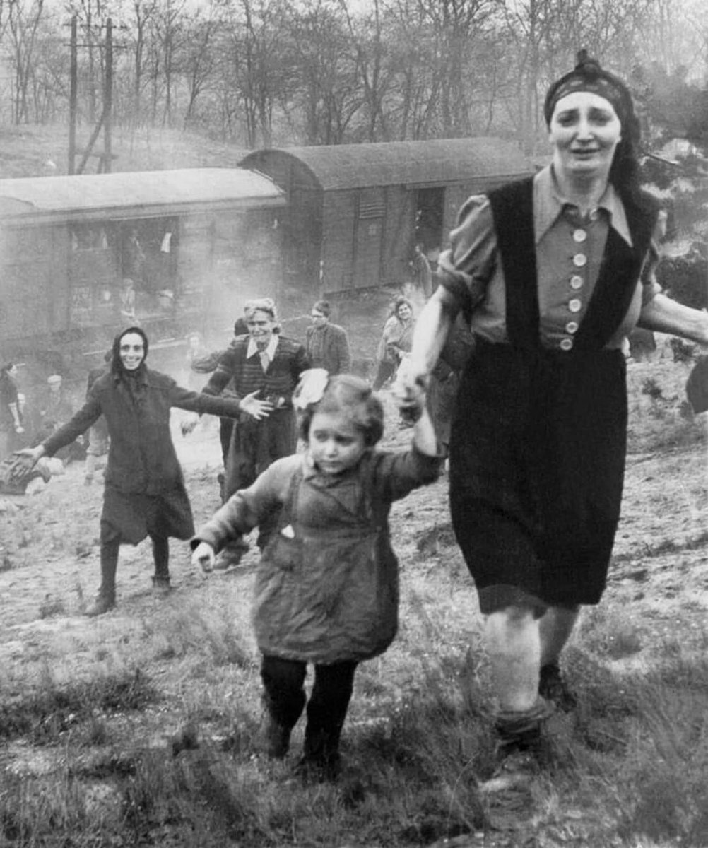 Picture was taken by Major Clarence L. Benjamin at the instant a few of the train people saw the tanks and first realized they had been liberated.