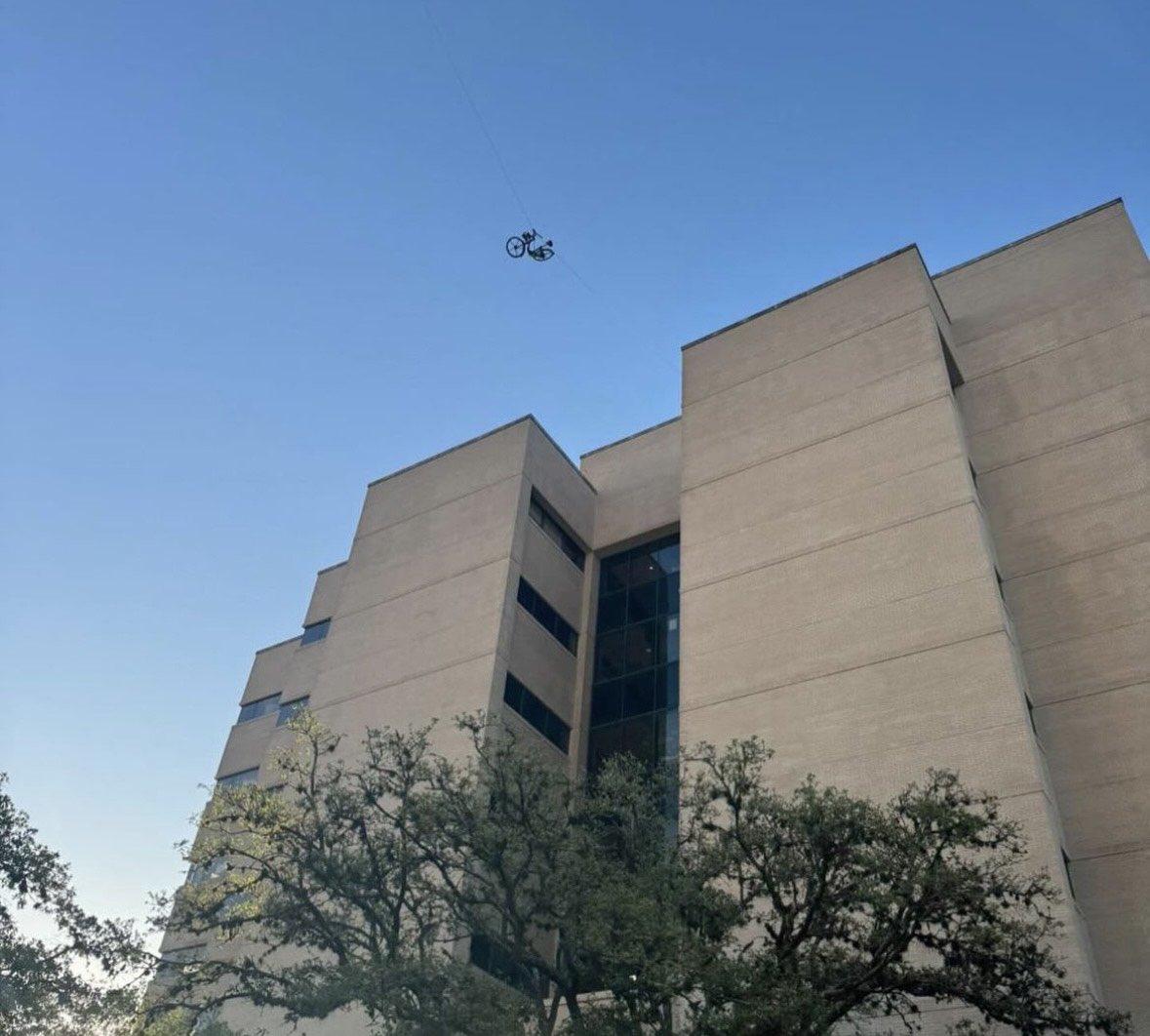 🚳 The College Station Fire Department is on A&M’s campus helping to get a bicycle down that was left dangling between two buildings. 📸; Andrew Billingsley and Katy Grace