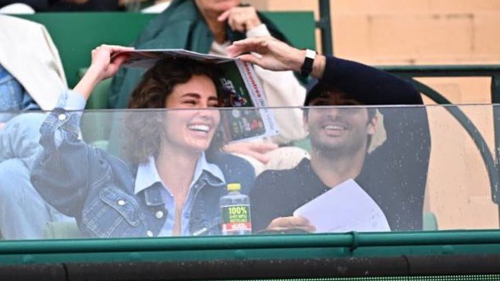 not carlos sainz using a magazine to shield his girl from the sun 🥹 how can they be so cute