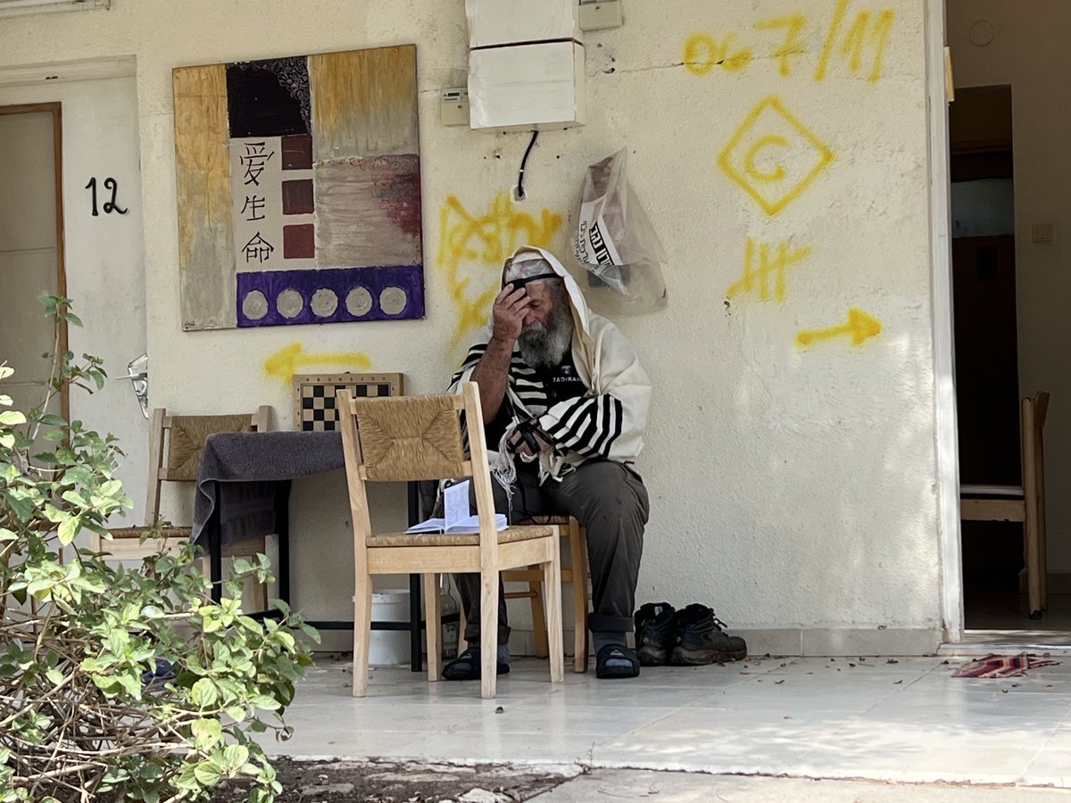 A man in prayer outside a home amid the wreckage in Kibbutz Nir Oz 🇮🇱