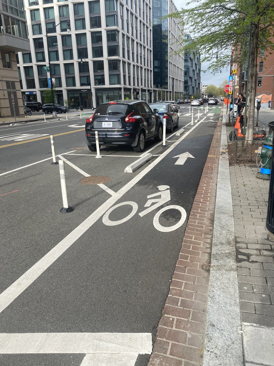 Story time, kids! Come close. This is a protected bike lane on I St SE in DC. In 2016 I lived on this block. The original configuration had car parking at the curb and painted bike lanes.