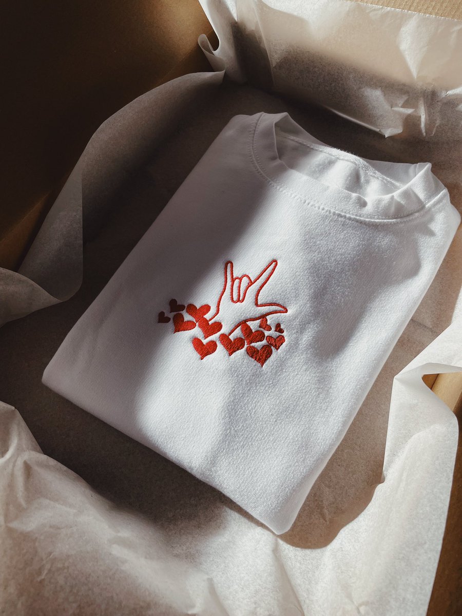 Show the love with our ILY Hand Sign With LoveHearts seen here in Red embroidery on White sweater! 🤍❤️ Order and personalise yours now at deafidentity.com ✨